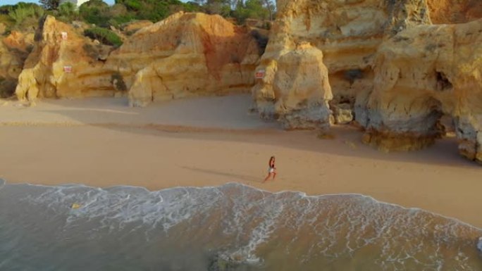 一名年轻女子正在享受沿海地区沙滩上的水流