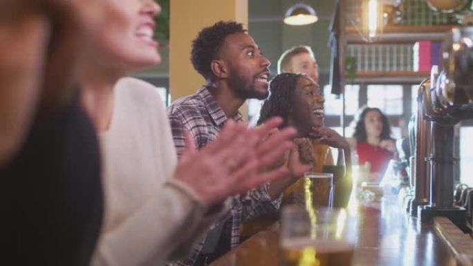 一群失望的顾客在体育酒吧观看电视上的体育赛事，团队在慢动作中失利