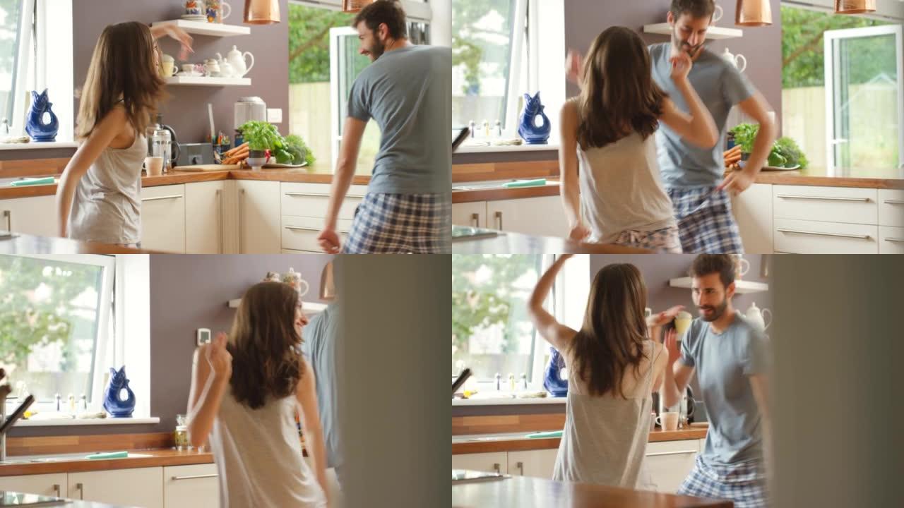 一对年轻夫妇在厨房里一起跳舞的4k视频片段