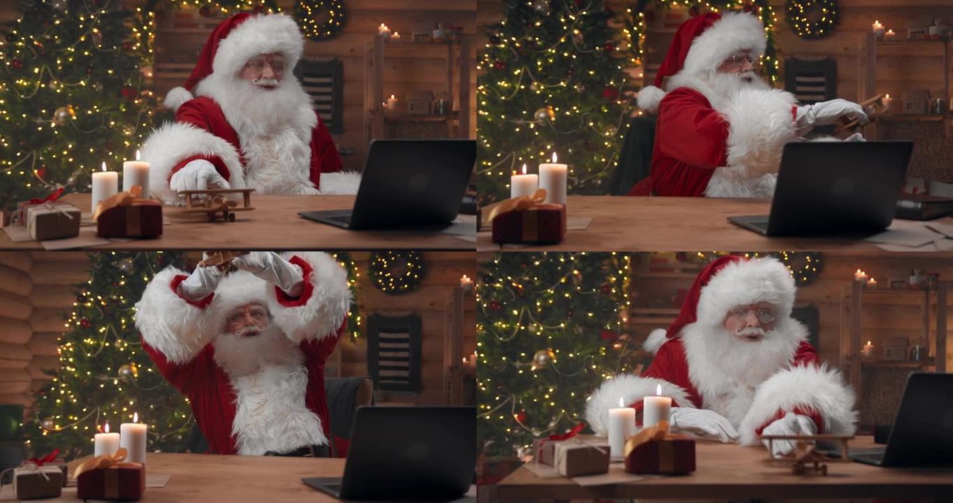 圣诞老人在他的笔记本电脑上开始视频会议，并展示了一架可爱的木制飞机，他要给一些孩子