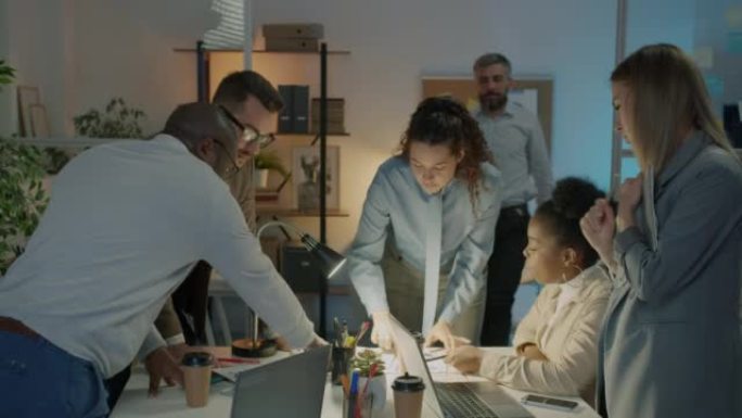 Group of office workers talking looking at documen