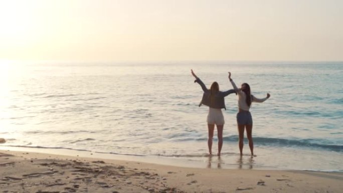 在意大利度假期间，两名无法识别的妇女在日落时在海滩上结为纽带的4k视频片段