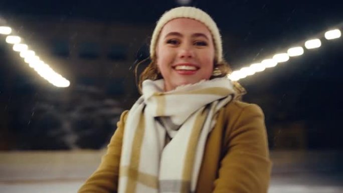 溜冰场上的冬季仙境: 美丽女孩与伴侣滑冰的视点肖像。快乐微笑的女人。恋爱中的情侣跳舞有趣，花样滑冰。