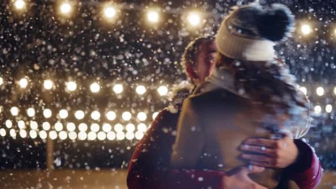 浪漫的冬天下雪的夜晚: 滑冰夫妇在溜冰场上玩得开心，旋转和跳舞。户外双人滑冰。温柔的年轻人，恋爱中的