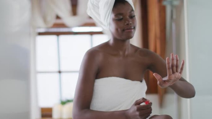 非裔美国迷人的女人在浴室修指甲