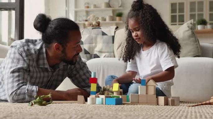 开朗的非洲爸爸在家和女儿玩木方块