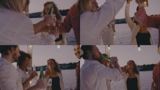 SLO MO一群朋友在船上的甲板上用啤酒瓶敬酒