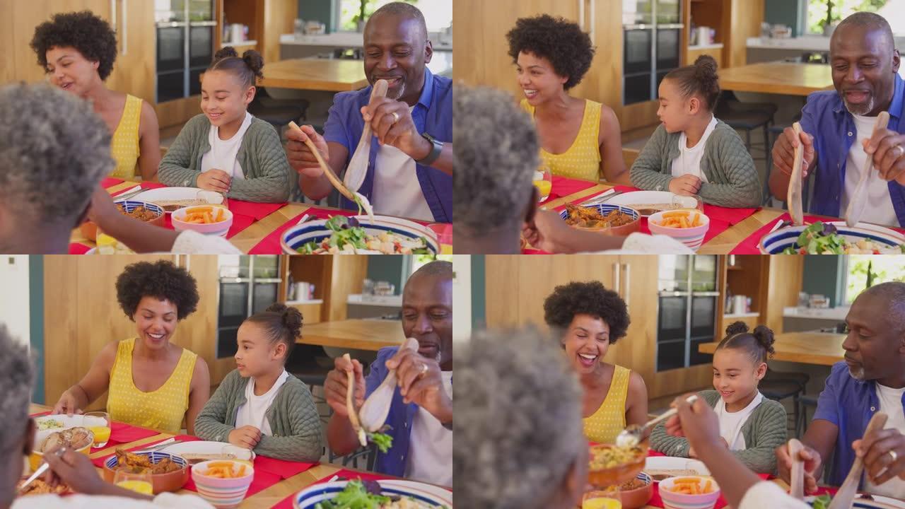 多代家庭坐在家里的餐桌旁一起吃饭和吃饭 -- 慢动作拍摄
