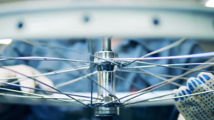 工业工人正在调整自行车车轮上的辐条