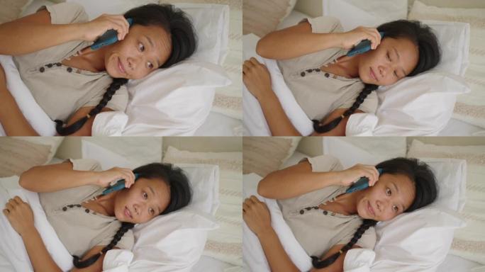 女人日本人躺在床上，一边用手机说话