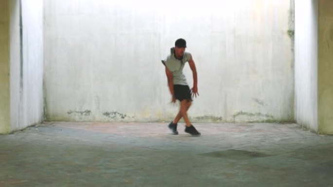 男子，舞蹈和嘻哈风格，在体操霹雳舞中使用墙壁，以在城市中健身和健康。舞者，舞蹈和训练，具有灵活而强壮