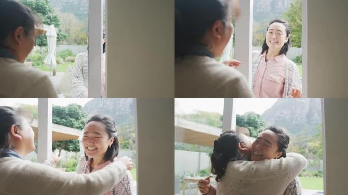 快乐的亚洲母亲拥抱成年女儿到达后门