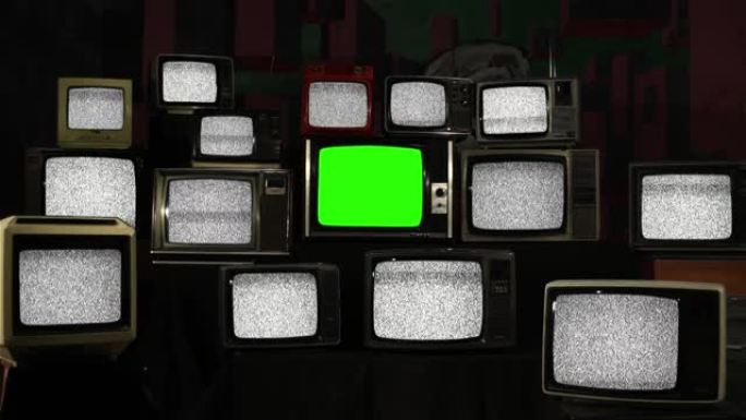 一堆带有静电噪声和复古电视绿屏的复古电视。放大。
