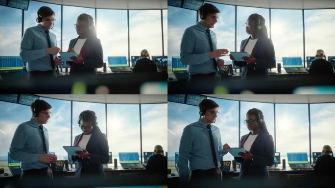 带着耳机的男女空中交通管制员在机场塔台交谈。办公室充满了台式计算机显示屏，带有导航屏幕，飞机出发和到