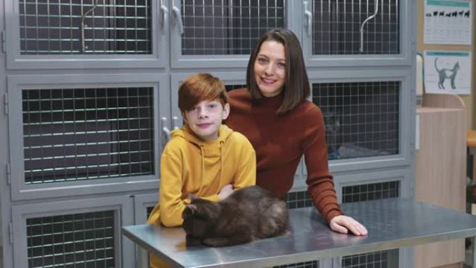 妈妈和儿子在兽医诊所与英国短毛猫