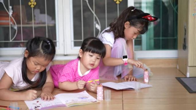 三个小女孩在家画画学习