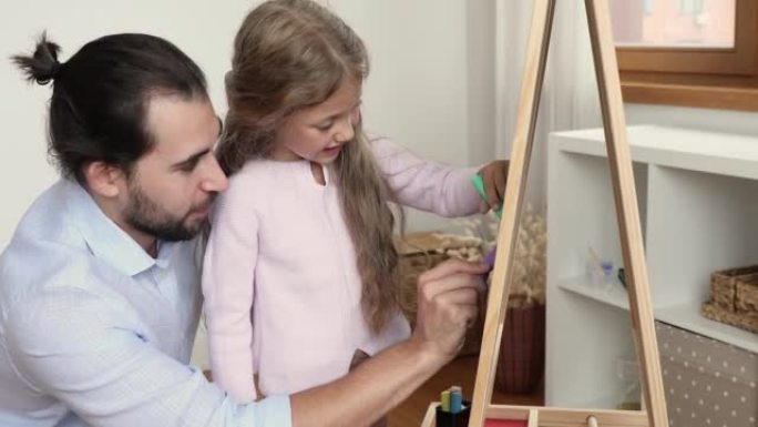 慈爱的父亲和女儿用粉笔在船上画画