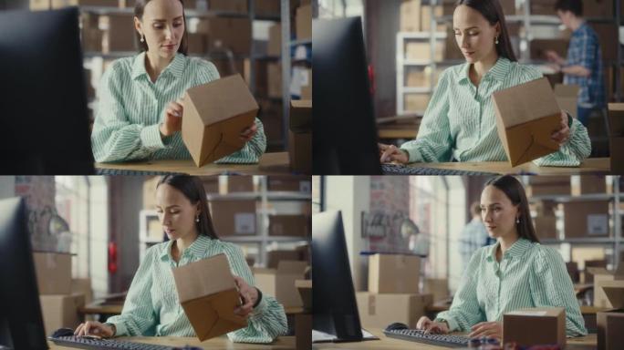女性仓库销售经理坐在储藏室时在台式计算机上工作。在后台，员工在装满纸箱包裹的仓库中工作，准备运输。