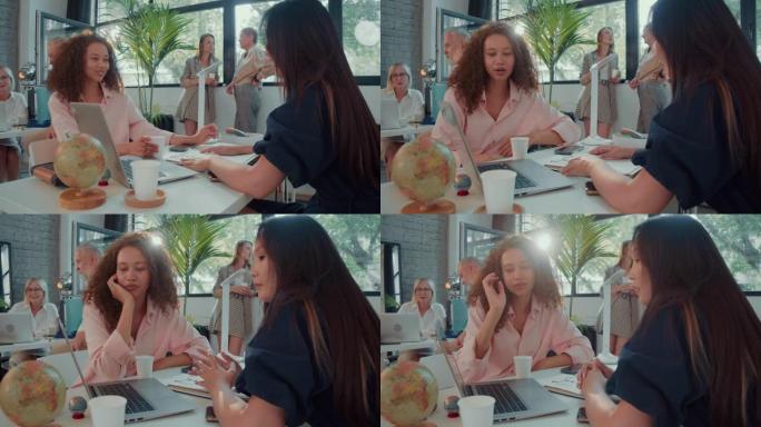 快乐的多种族女性同事，经理们在大灯现代办公桌慢动作中使用笔记本电脑一起工作。