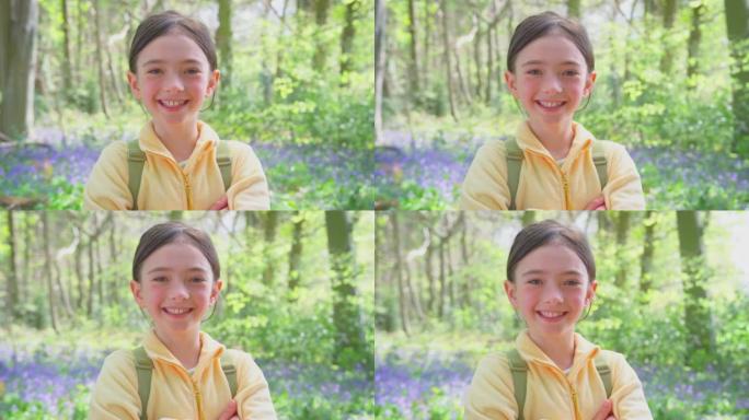 微笑女孩的肖像带着风铃草穿过春天的林地-慢动作拍摄
