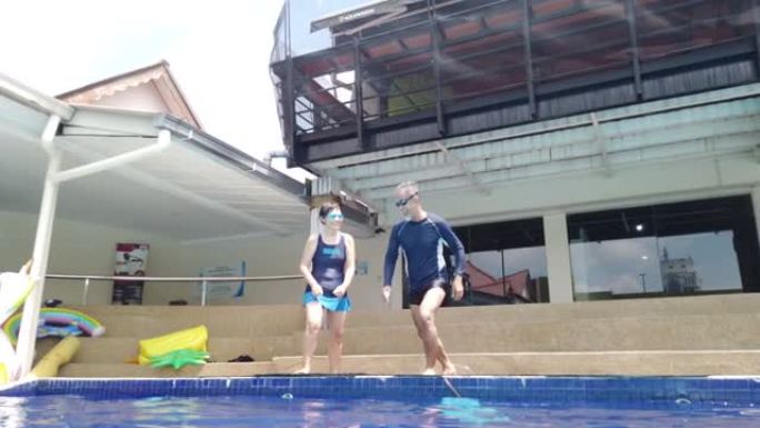 亚洲华裔老年夫妇跳进泳池快乐享受