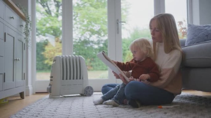 生活成本能源危机期间，母亲和儿子在家里用散热器插上插头画画