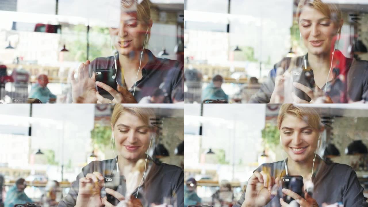 4k视频片段，一位迷人的年轻女商人独自坐在咖啡馆里，用手机进行视频通话
