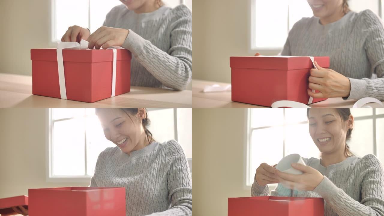 快乐亚洲女人打开礼品盒