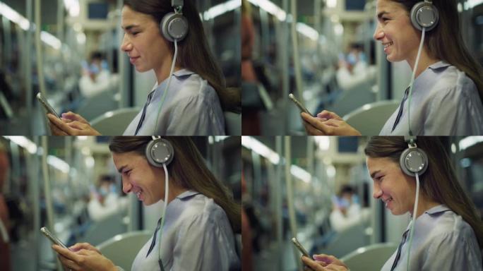 微笑的女人在乘地铁旅行时使用智能手机和耳机听音乐。女性员工使用公共交通工具回家，通过社交媒体浏览，在