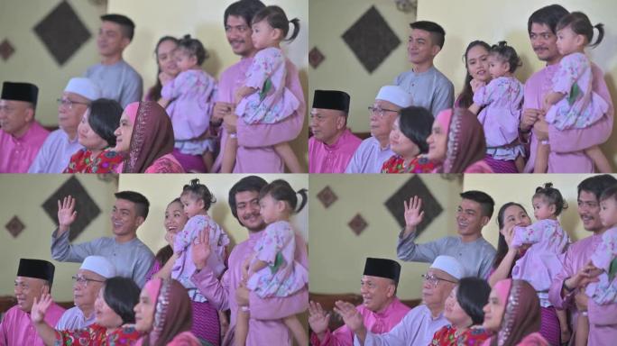 马来西亚马来人一家人在家里挥舞着庆祝hari raya的相机拍照
