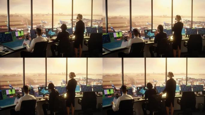 日落时在现代机场塔楼工作的多元化空中交通管制团队。管制员在装满计算机的房间里拍手庆祝新商用飞机的首次