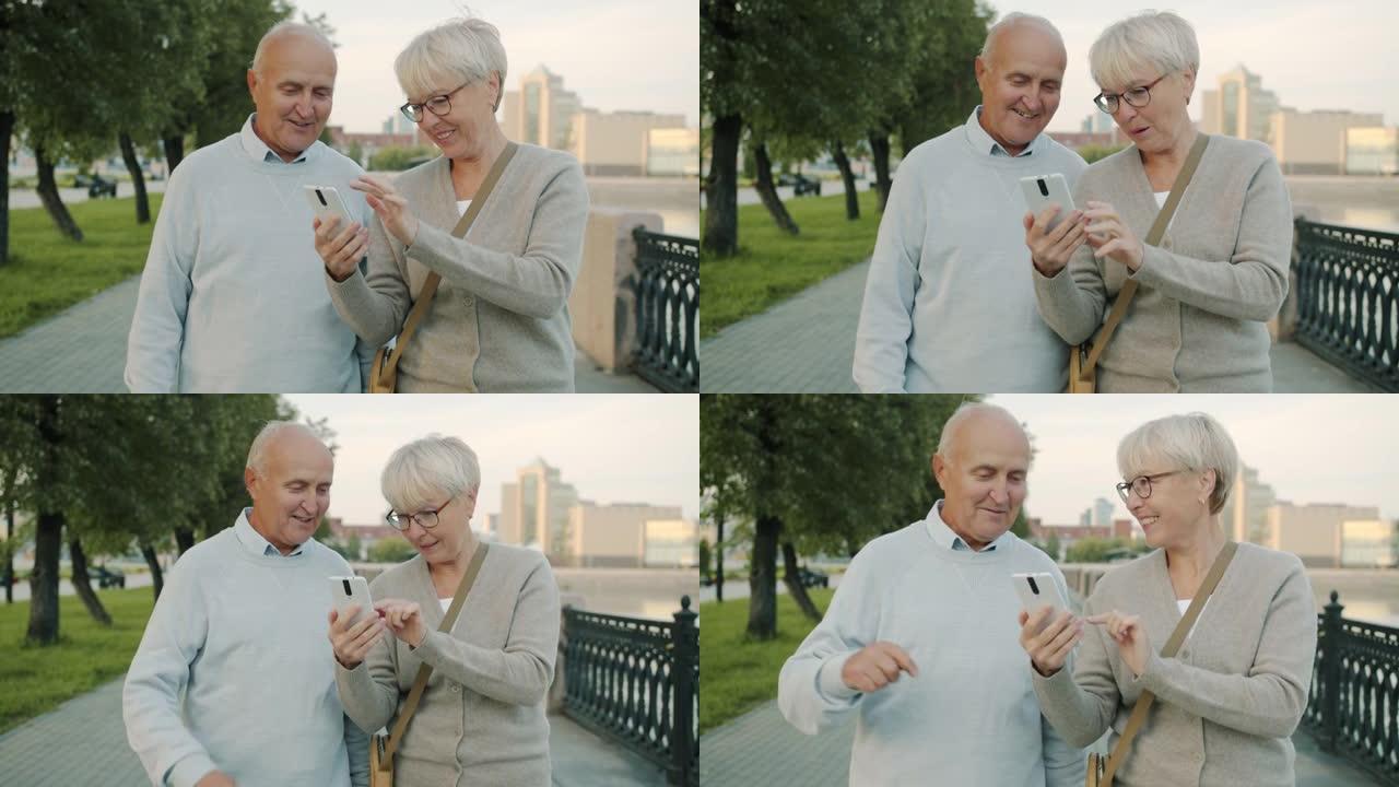 在夏日，使用智能手机在河堤上行走的老年夫妇的慢动作