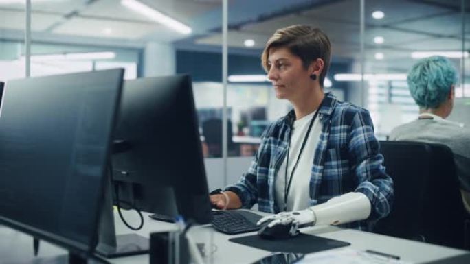 多样化的身体正面办公室: 使用假肢在计算机上工作的有动力的残疾妇女的肖像。具有先进思想控制身体动力肌