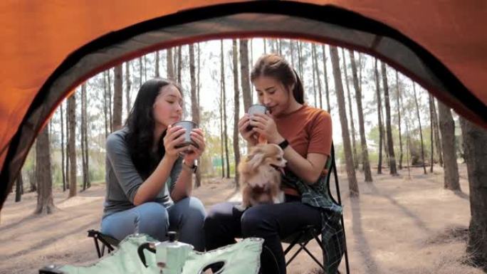 女人坐在帐篷前，在露营旅行中喝咖啡