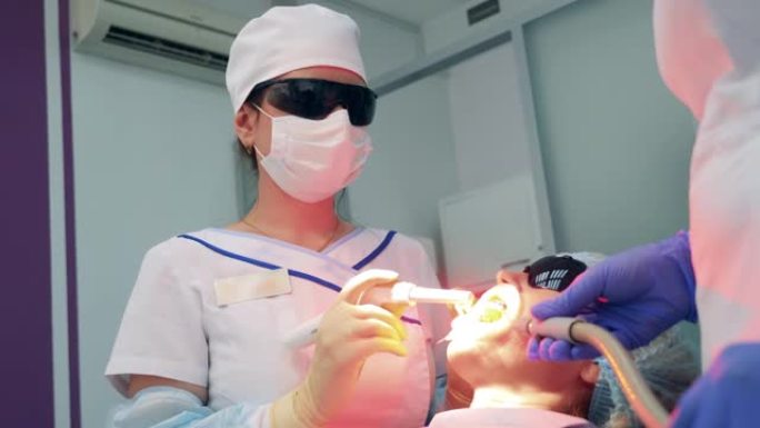 牙医在漂白时点亮患者的牙齿