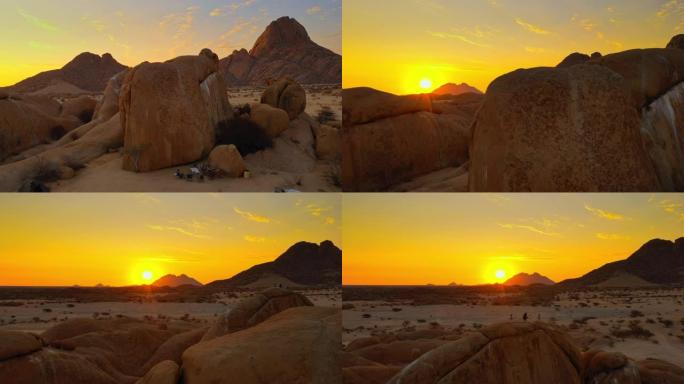 WS游客在日落时分在偏远沙漠的岩石上露营，纳米比亚，非洲