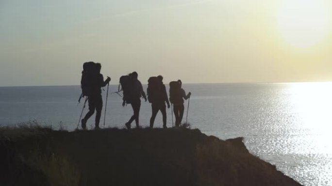 四位旅行者靠着海景走向山崖