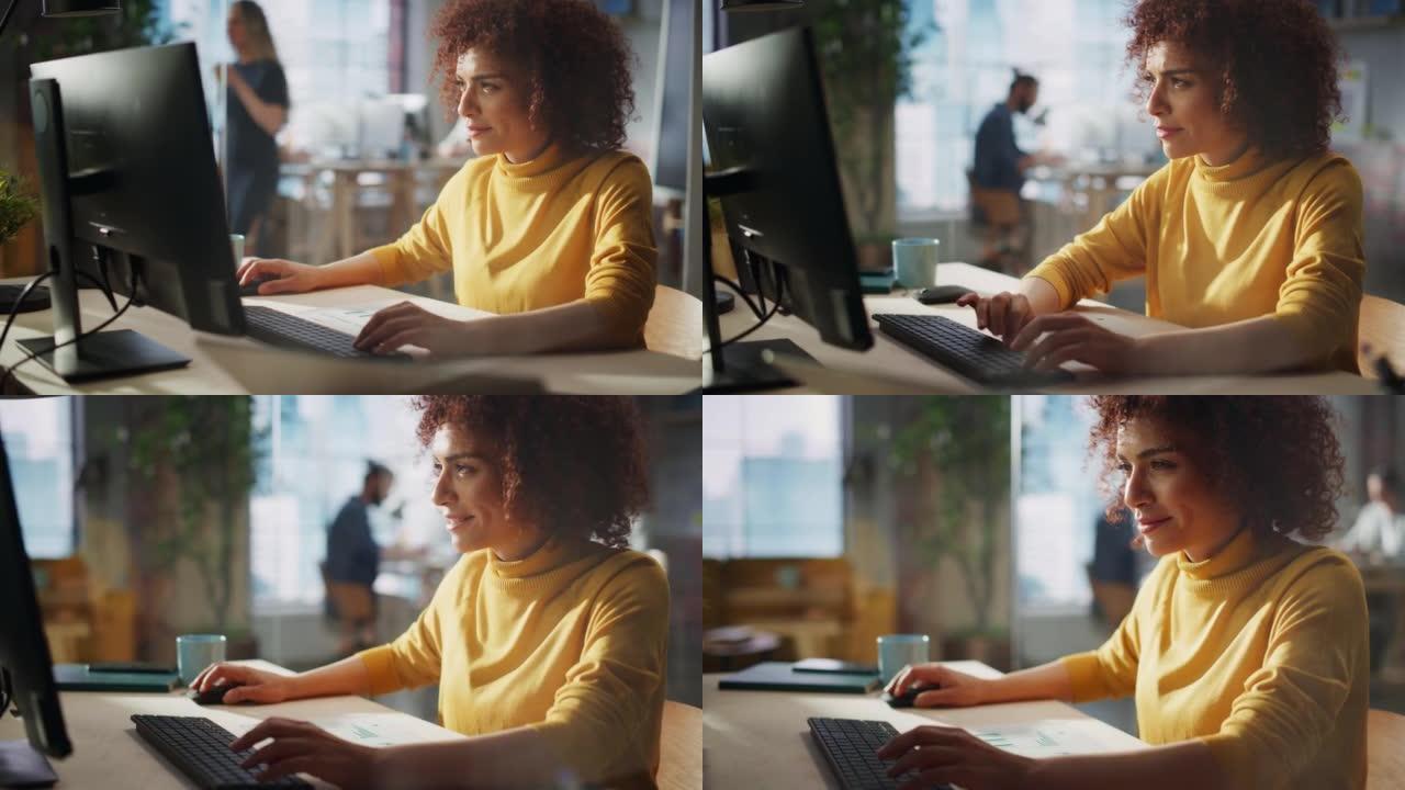 特写一位在创意办公室工作的快乐中东经理的肖像。年轻时尚的女性，卷发，在营销机构使用笔记本电脑。玻璃墙