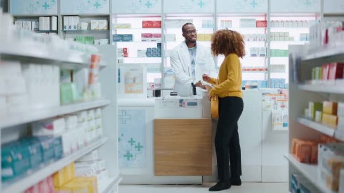 药房药店收银台: 专业的黑人药剂师向不同群体的多民族顾客出售药品，他们使用非接触式支付信用卡购买药品