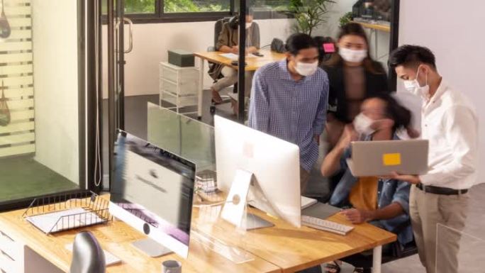 4K UHD俯视图平移左延时: 忙碌的创意现代办公生活。办公室员工工作会议在新的正常社会远程办公室讨