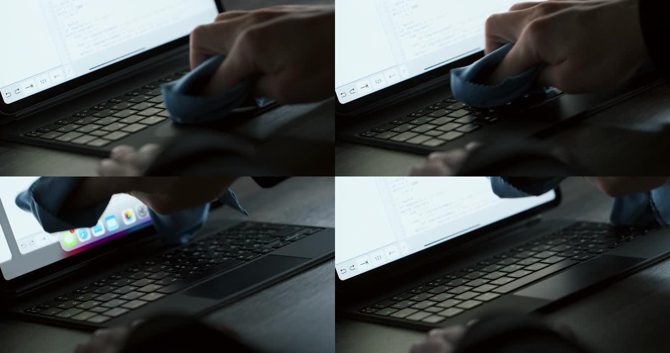 用特殊的超细纤维布清洁黑色笔记本电脑的人手特写
