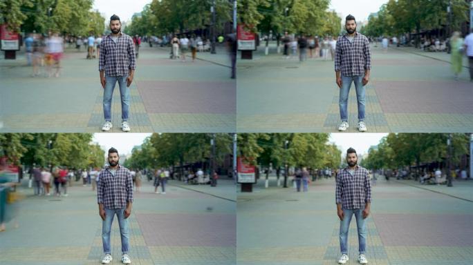 站在拥挤的街道上看着相机的迷人阿拉伯男子的延时肖像