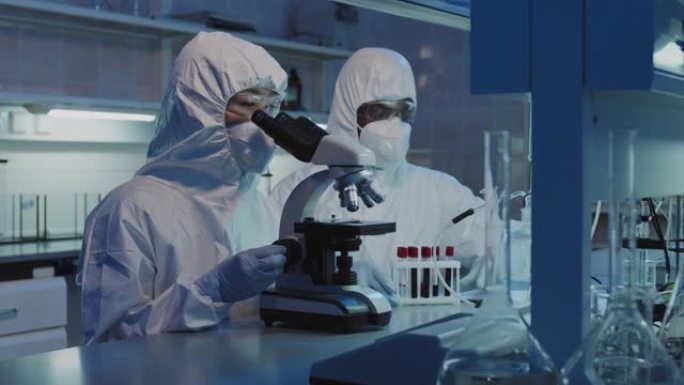 工作服和口罩的科学家在实验室进行研究
