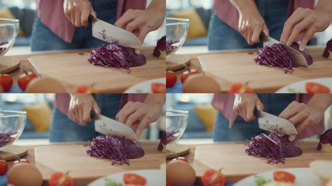 年轻的亚洲女厨师的手拿着刀在家里厨房桌子上的木板上切红色的大白菜。