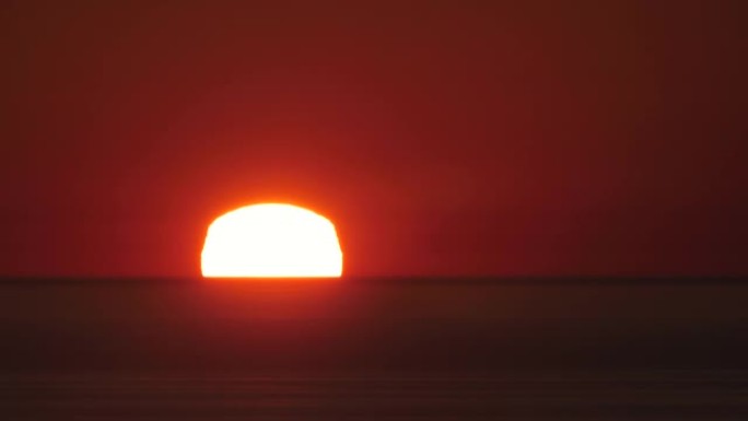 时间流逝夕阳红色的天空和美丽的大海。令人惊叹的橙色阳光壁纸在反射的海洋画面。夏日阳光海景。自旋漂移云