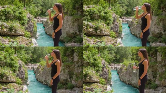 快乐的女游客在山溪享受壮丽的景色，喝水