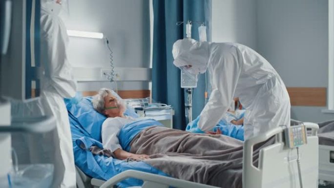医院冠状病毒急诊科病房: 一组医生穿着工作服，口罩照顾一名躺在床上的高级患者，戴上氧气面罩并连接静脉