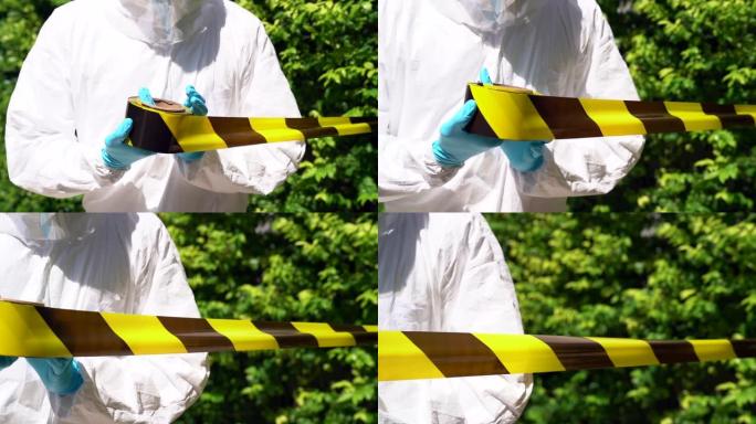 穿着PPE服的慢动作医务人员在感染冠状病毒新型冠状病毒肺炎的患者家中用黄色警告带为隔离和检疫区域设置