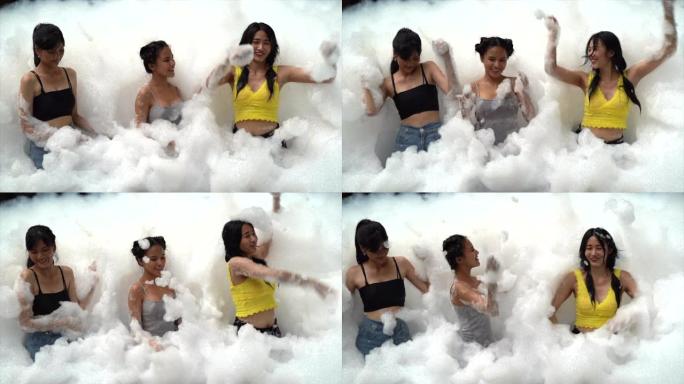 4k慢动作视频镜头三个亚洲青少年在假期玩一个有趣的泡沫派对。泰国曼谷
