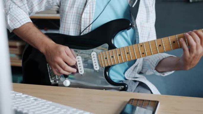录音室室内吉他手手演奏电子乐器的特写慢动作